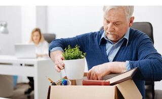 Laid off Older Worker packing up his desk